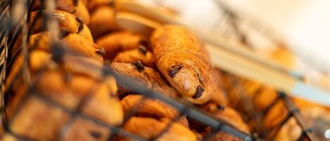 Una cesta con una variedad de productos horneados, como croissants y otras bollerías.