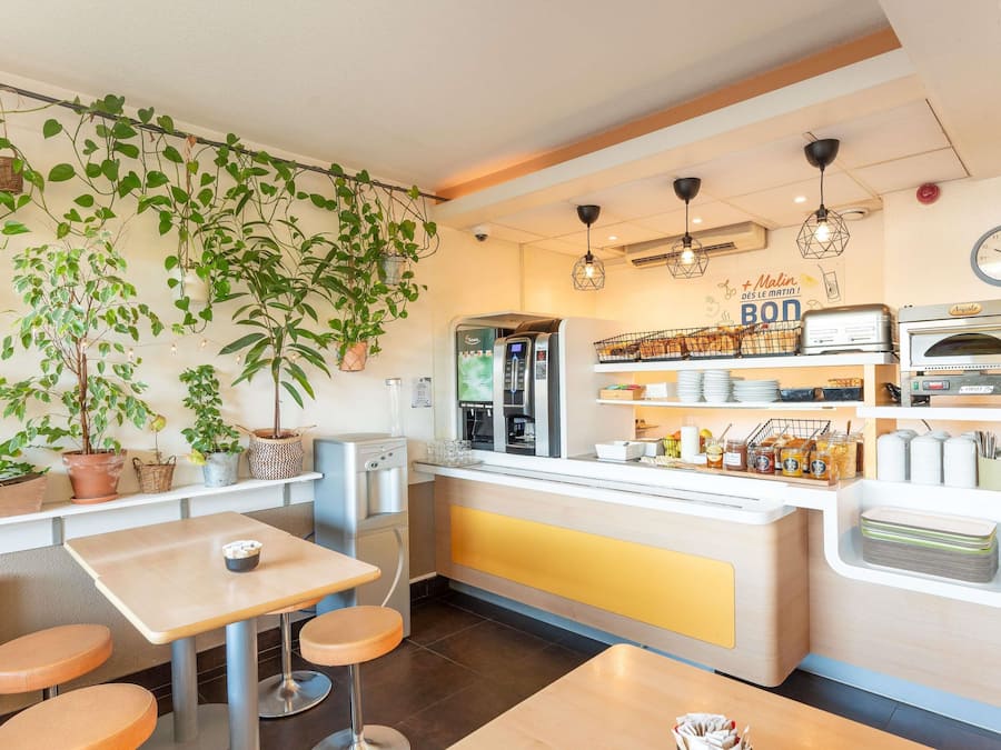 Ein Café mit Theke, Sitzbereich und diversen Pflanzen.
