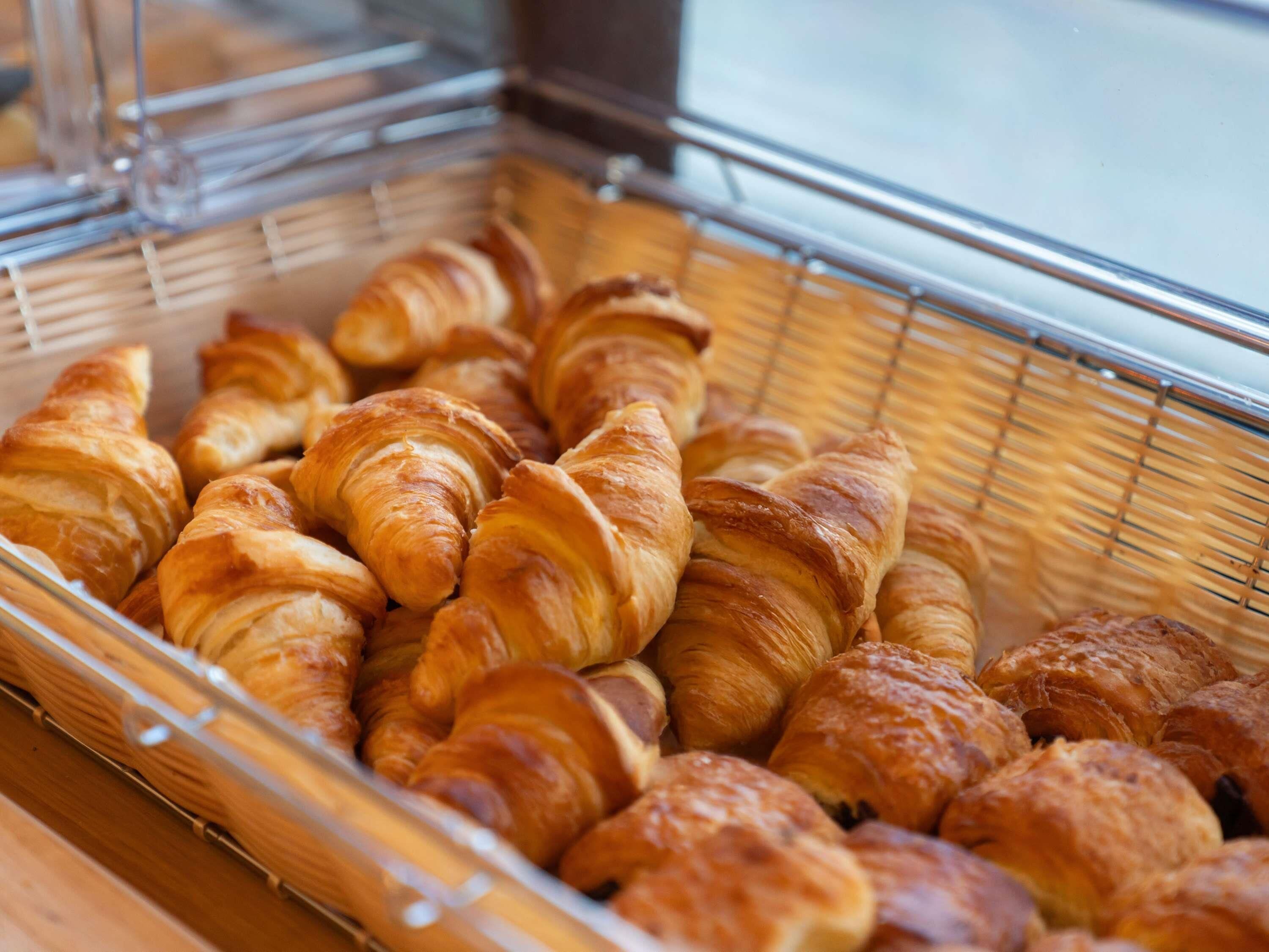 A display case filled with various types of pastries, including croissants and other baked goods.