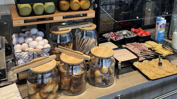 A breakfast display with fruits, eggs, bread, and dairy products.