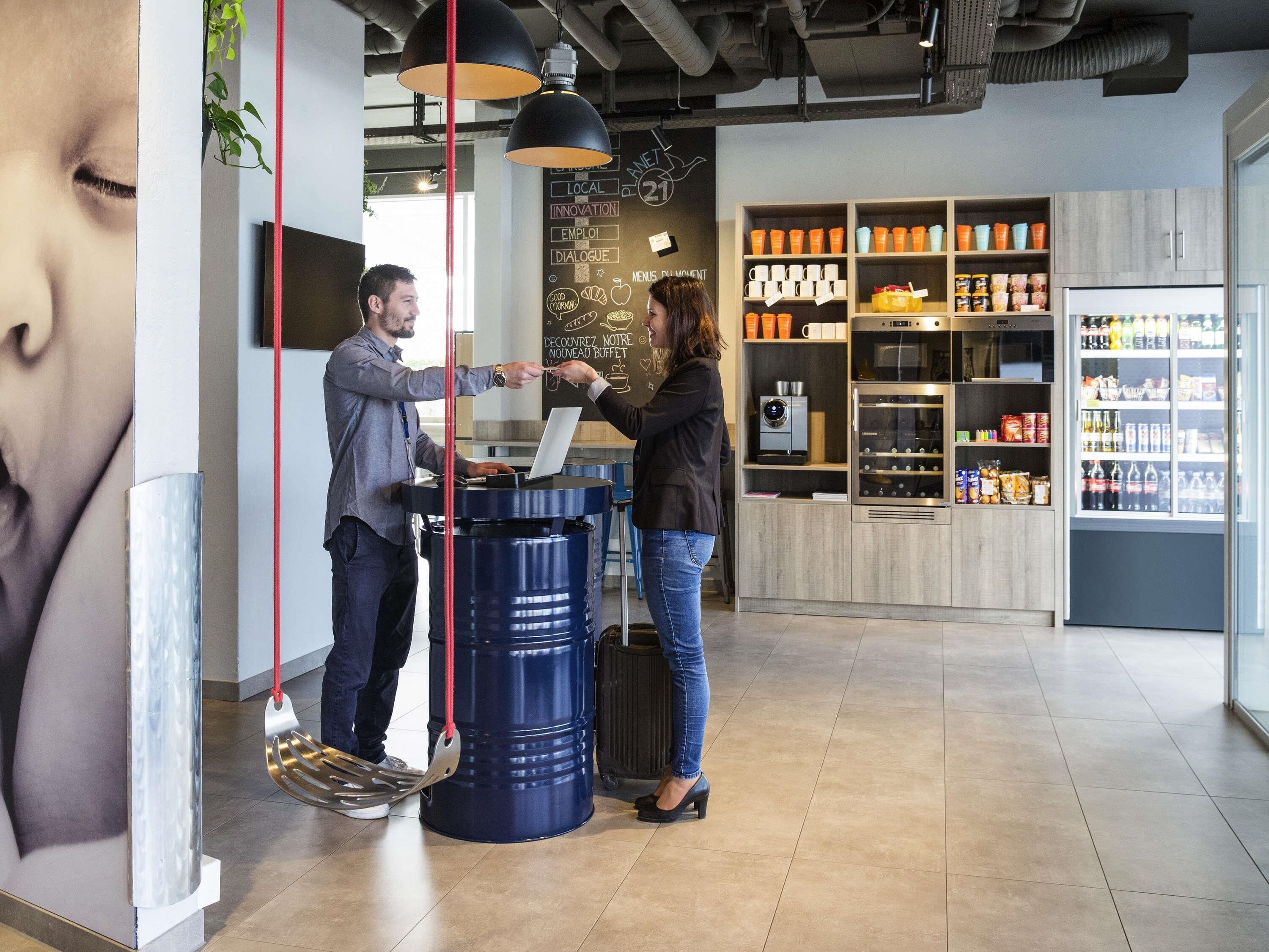 L’intérieur d’un café moderne est doté d’un écran numérique affichant le menu, d’une machine à café et d’un réfrigérateur rempli de boissons.