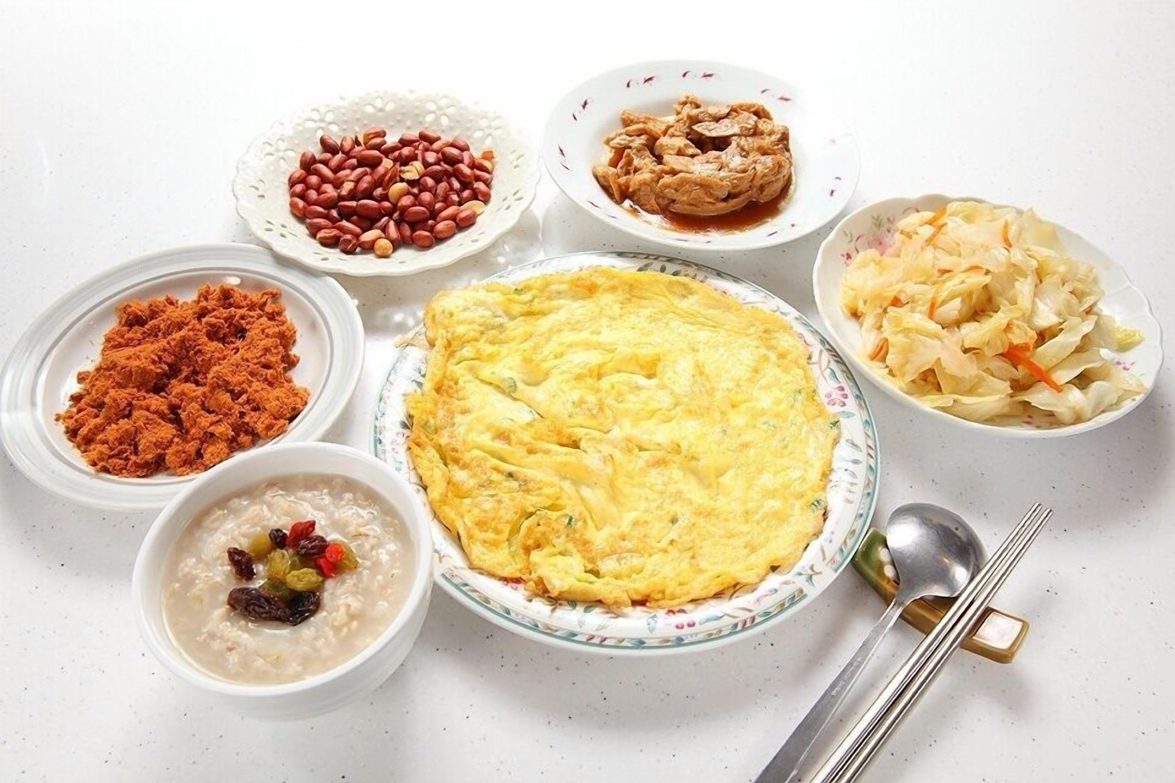 Un assortiment de plats comprenant une omelette, des haricots, un plat de viande et une salade.