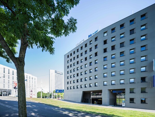 A modern building with a flat facade, multiple windows, and a sign reading 'ibis budget.' - ibis budget Basel City (Basel)