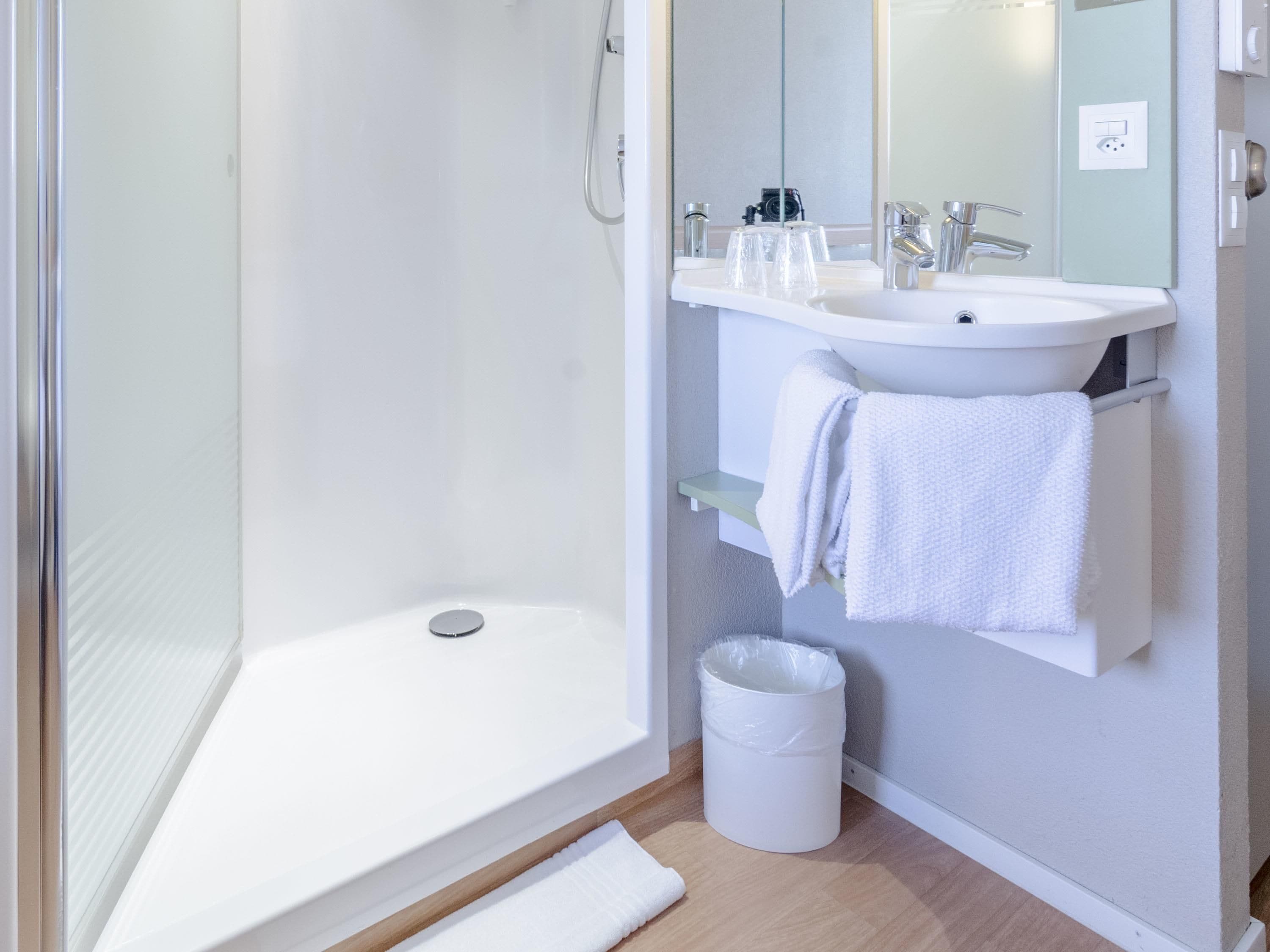 Une salle de bain moderne équipée d’une douche, d’un lavabo et de toilettes.