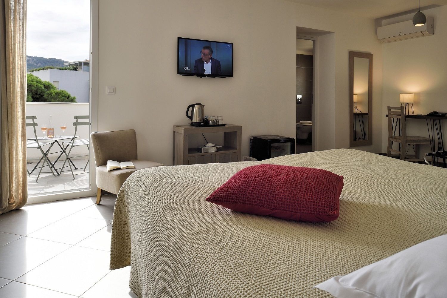 Una habitación de hotel con cama, televisión, escritorio y silla.