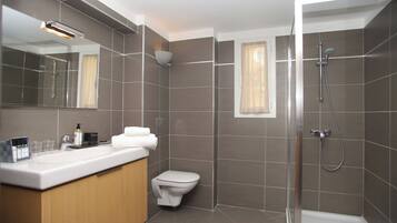 Un baño moderno con ducha, inodoro y tocador.