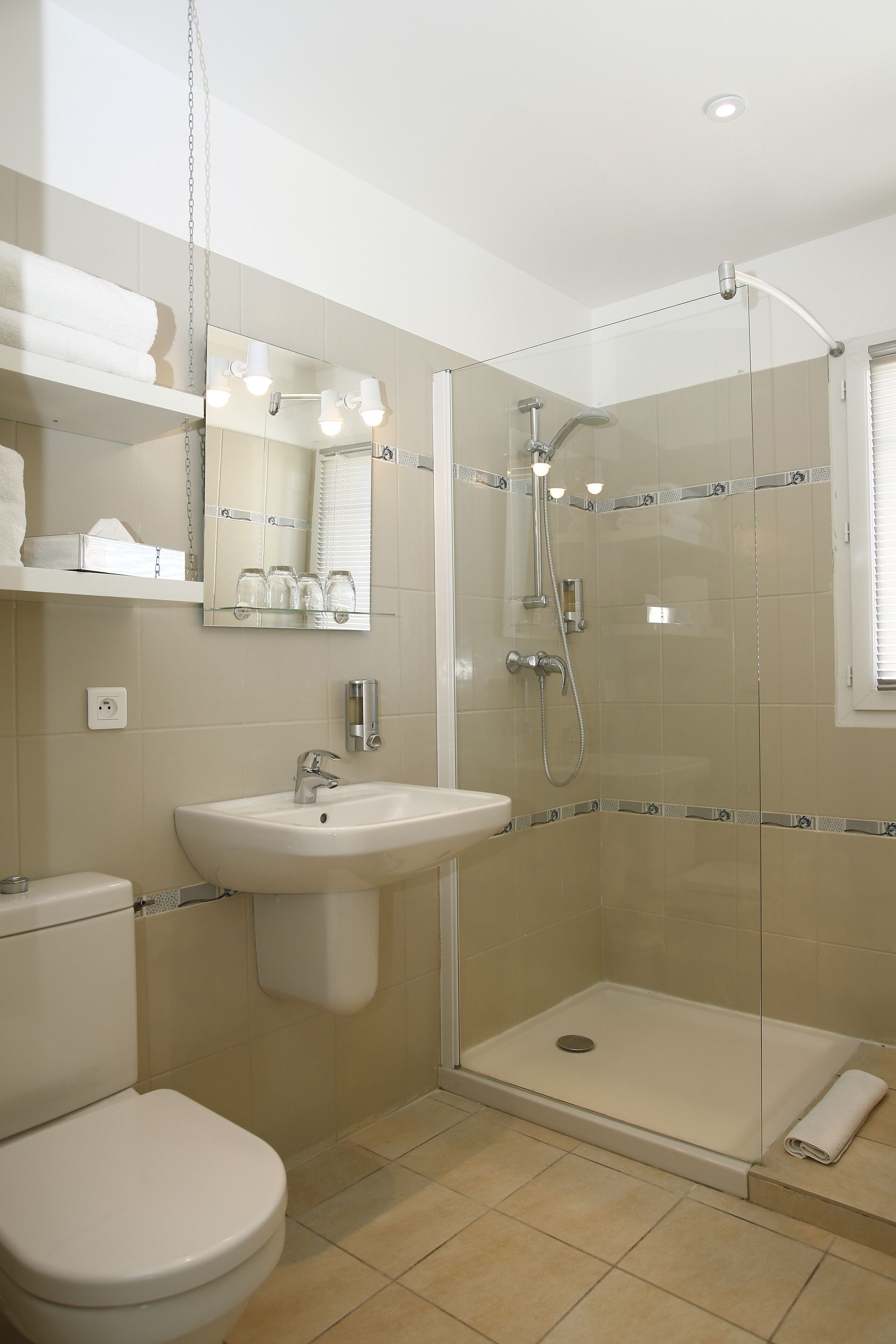 A modern bathroom with a glass-enclosed shower, a sink, and a toilet.
