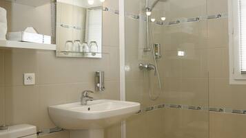 A modern bathroom with a glass-enclosed shower, a sink, and a toilet.