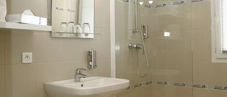 Une salle de bain moderne avec une douche à parois de verre, un lavabo et des toilettes.