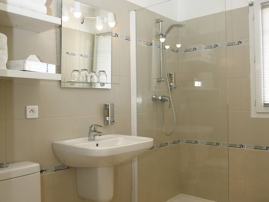 A modern bathroom with a glass-enclosed shower, a sink, and a toilet.