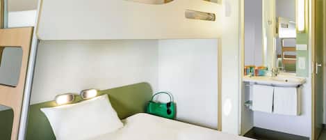 Una cama litera con una mesita de noche, un bolso verde y una tableta sobre la cama.