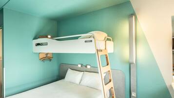 Una cama individual en literas con escalera, una mesita de noche y un aplique de pared.