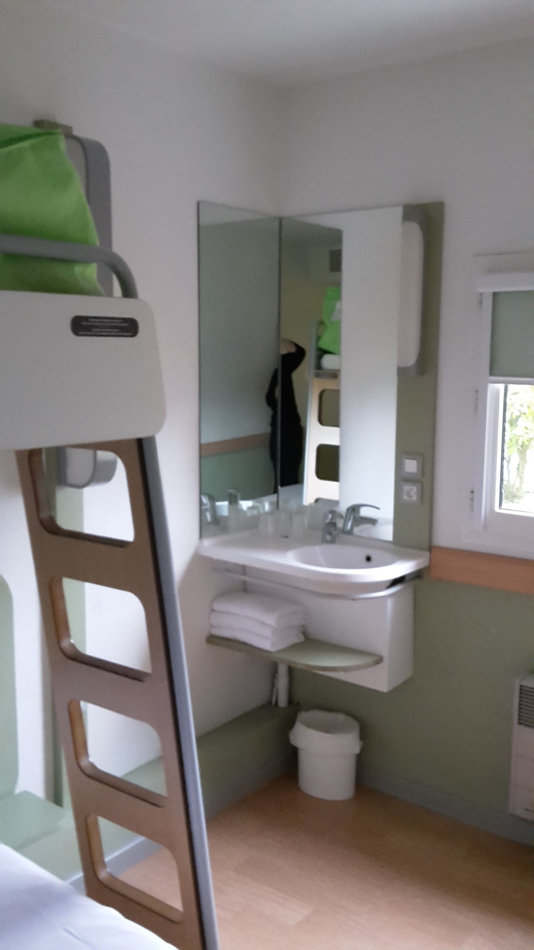 Uma casa de banho compacta com lavatório, espelho e janela.