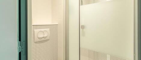 Une salle de bain avec une douche, des toilettes et un lavabo.