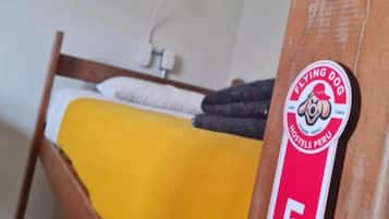 A bunk bed with a yellow blanket and a sign indicating room number 5.