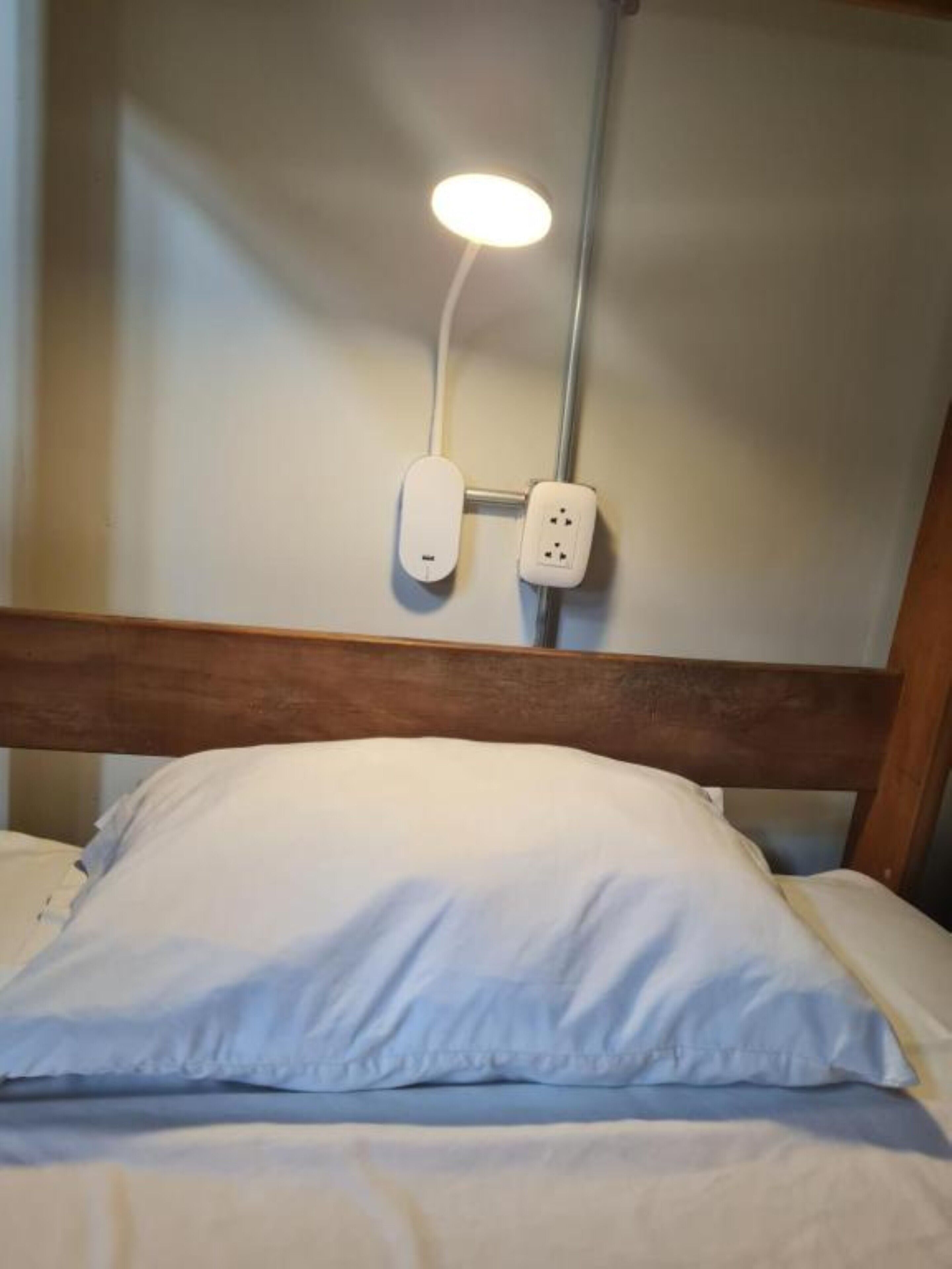 A bed with a white pillow and a headboard.