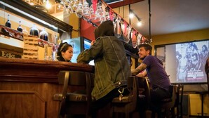 A bar area with wooden bar counters and hanging light fixtures. - Flying Dog Hostel B&B (Lima)