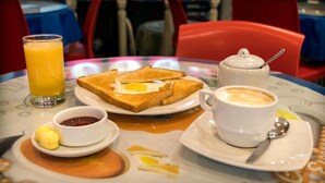 A breakfast table with toast, eggs, a glass of orange juice, a cup of coffee, and condiments. - Flying Dog Hostel B&B (Lima)