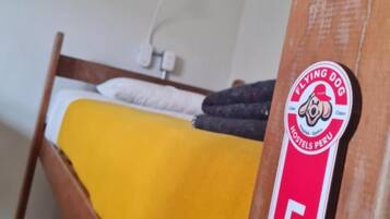 A bunk bed with a yellow blanket and a sign indicating room number 5.