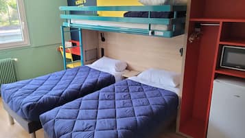 Quarto com duas camas, uma televisão pequena e um armário vermelho.