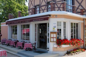 Un restaurante con mesas al aire libre y un letrero que dice "LE CHALET DE LA FORET RESTAURANT".