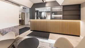 Un espace d’accueil moderne comprenant un bar, un comptoir de réception et des sièges.