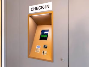 Un quiosco de registro con pantalla digital, teclado y lector de tarjetas.
