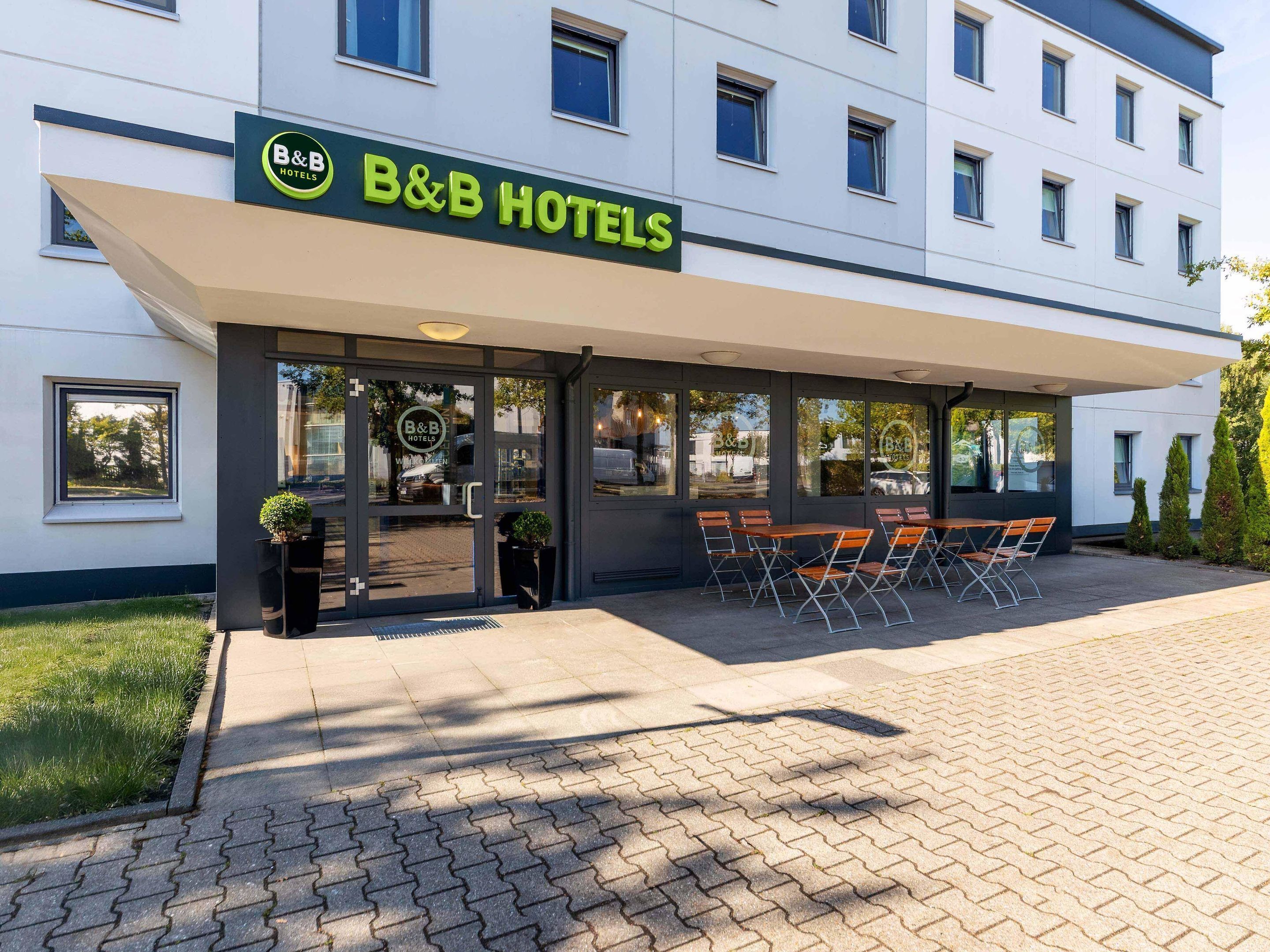 A B&B hotel with a covered outdoor seating area and a visible entrance.