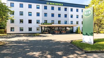 Ein Bed and Breakfast Hotel mit moderner Fassade, zahlreichen Fenstern und einem gepflasterten Eingangsbereich.