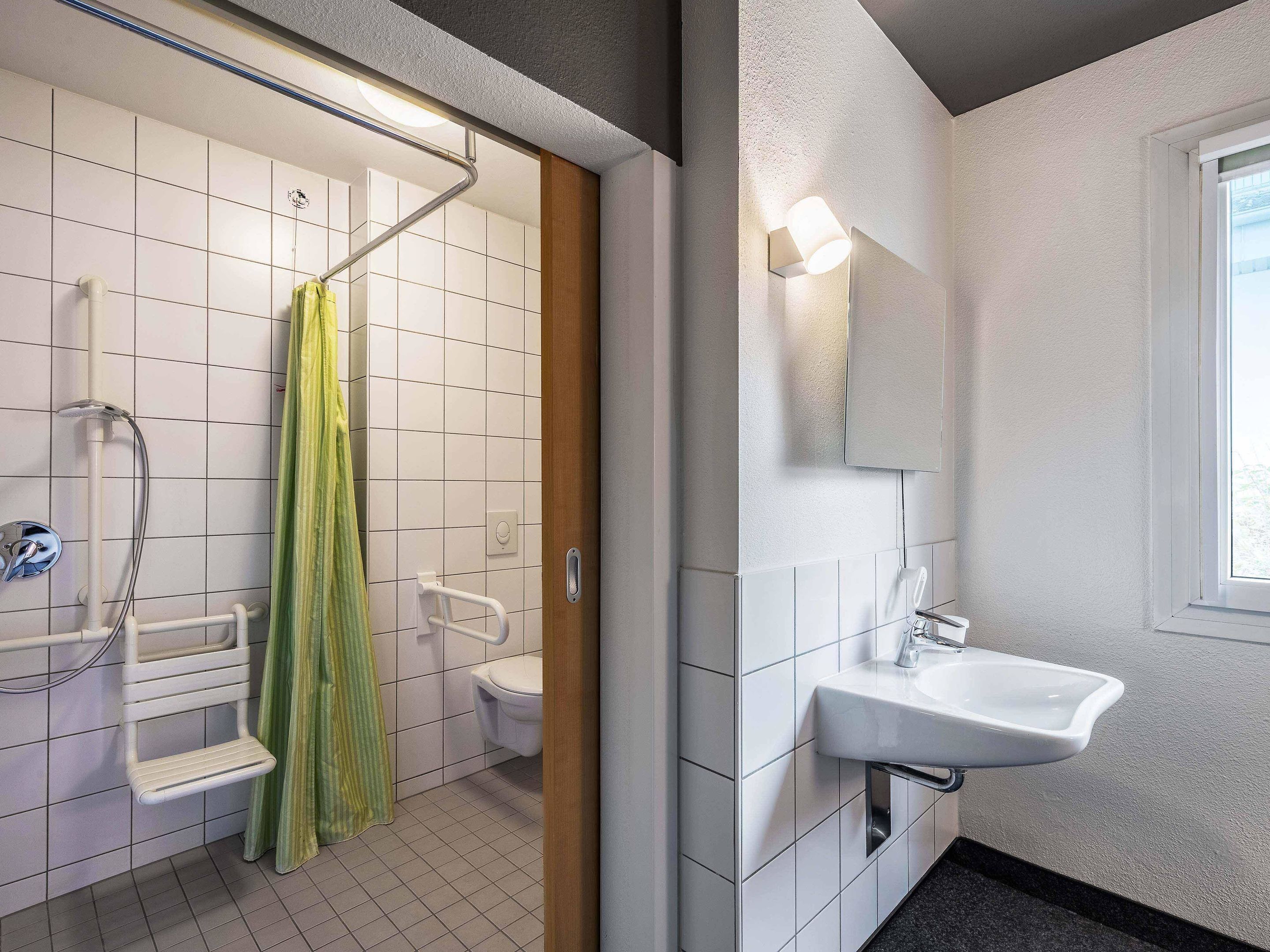 A bathroom with a shower, toilet, and sink.