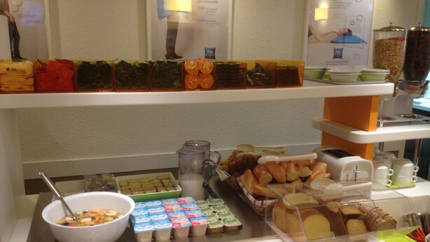 A buffet with various food items including pastries, yogurt, and a bowl of soup. - ibis budget Orgeval (Orgeval)