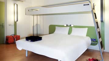 A bunk bed with a green headboard, a white mattress, and a pair of red shoes on the floor.