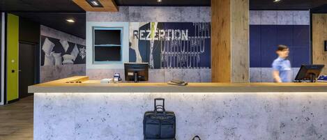 A reception desk with a wooden counter and a large wall mural.