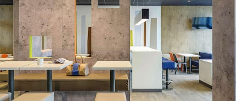 A modern interior with concrete walls, a central white table, and seating areas.