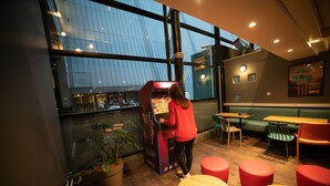 A modern interior with a vending machine, seating area, and large windows. - hotelF1 Paris Porte de Châtillon (Paris)