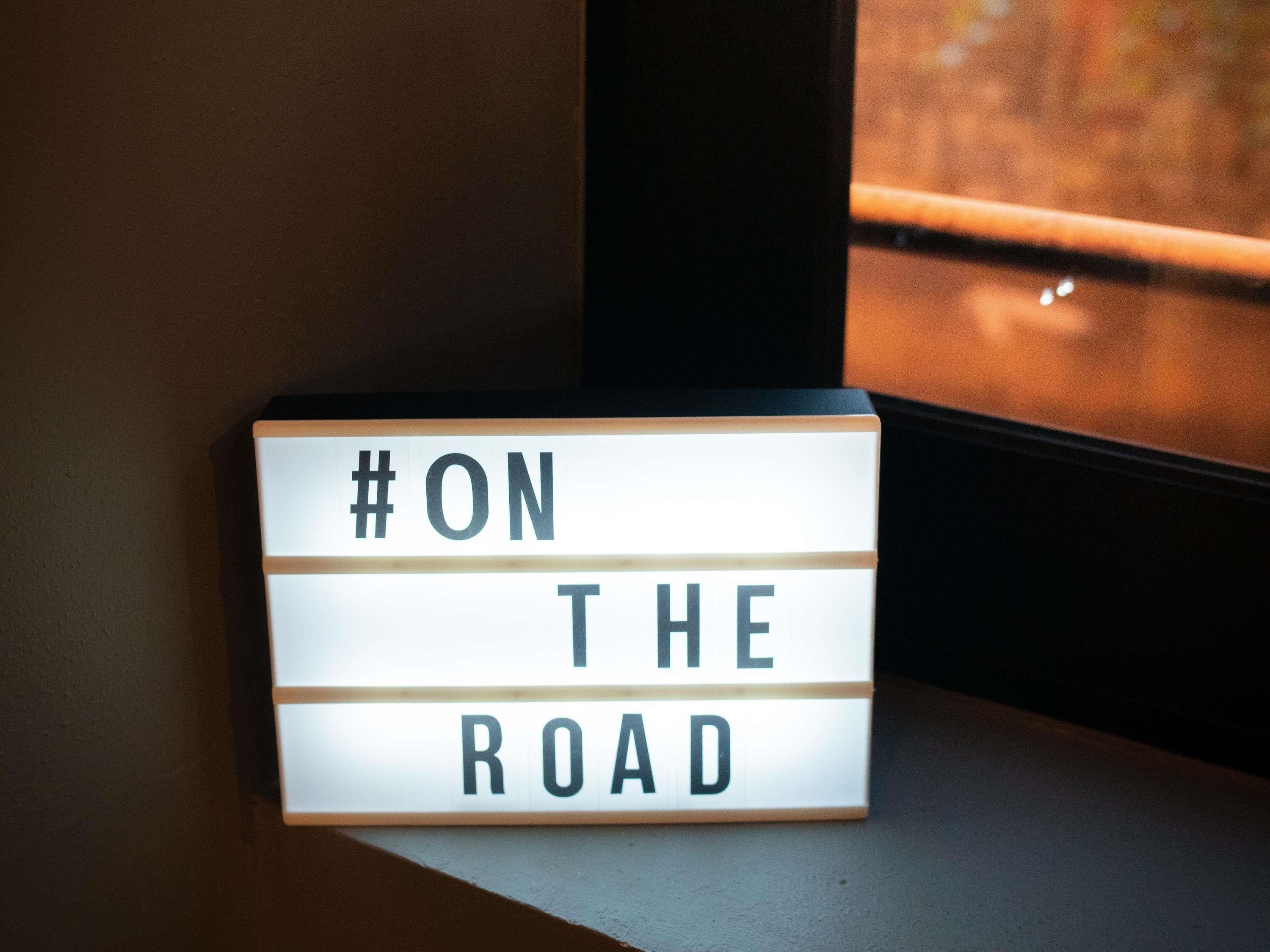 A lightbox sign with the text '#ON THE ROAD' on a window ledge.