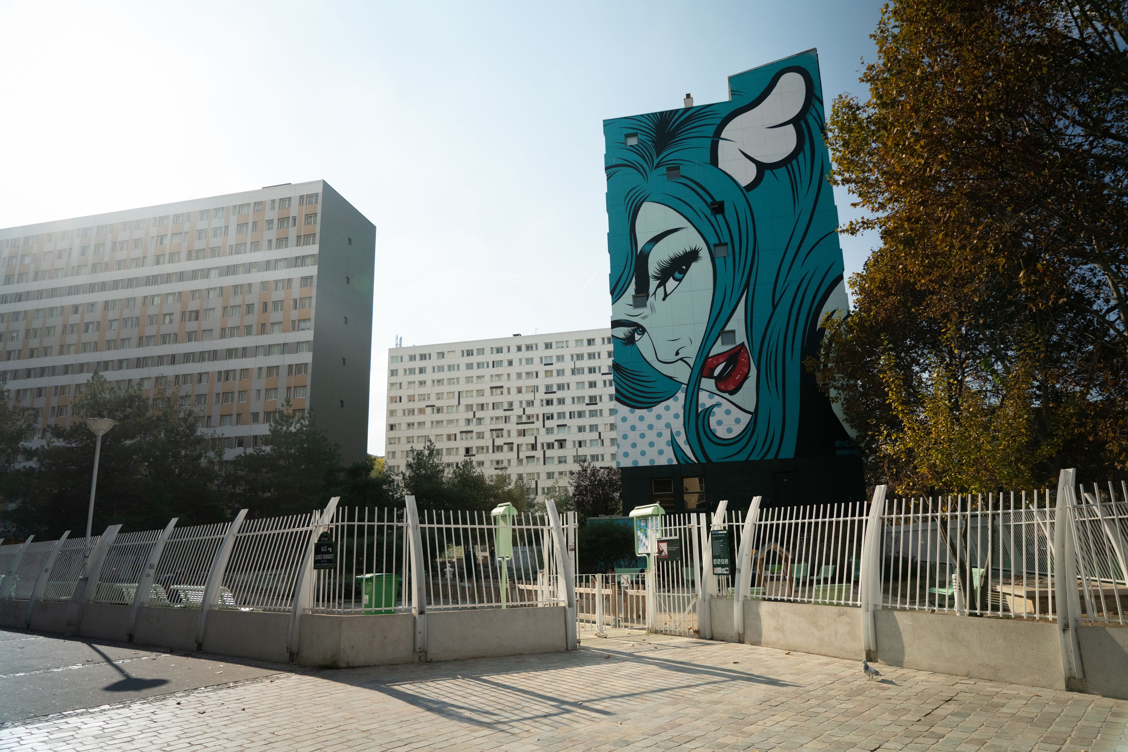 A building with a large mural of a woman on its facade.