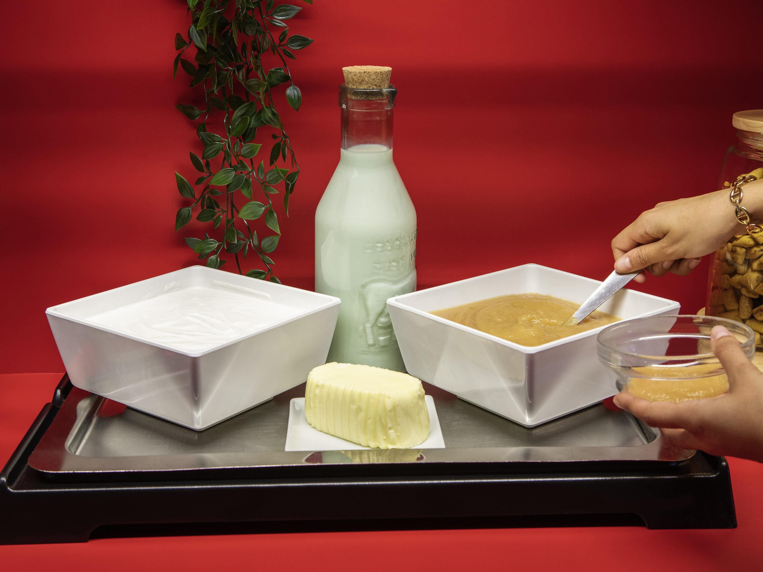 A tray with two white bowls, a bottle, and a hand holding a spoon.