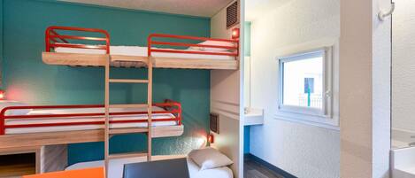 A bunk bed room with a window, a table, and a chair.