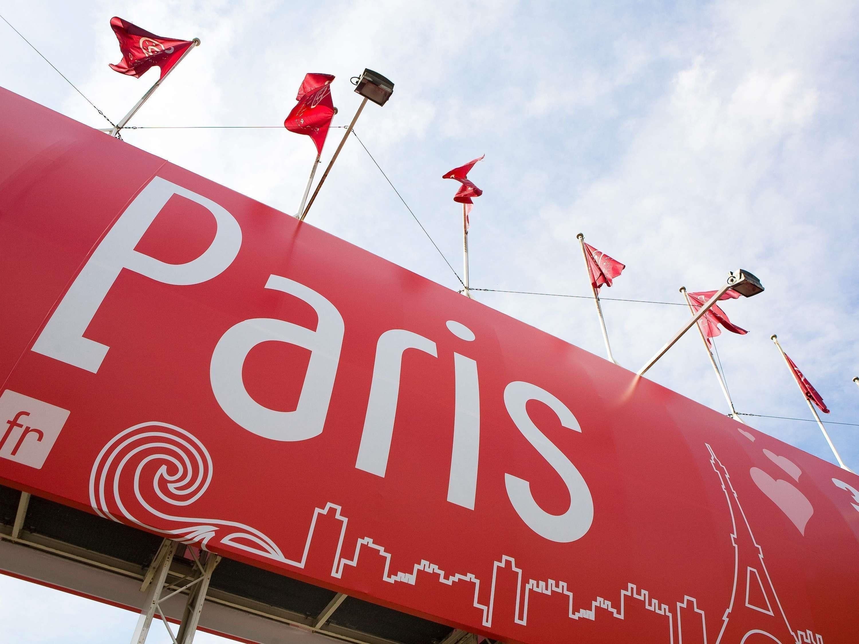 A large red sign with 'Paris' written on it, featuring the Eiffel Tower and a city skyline.