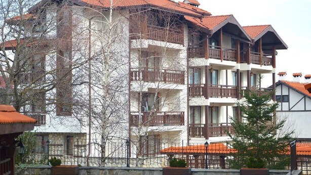 A multi-story hotel with balconies, a stone facade, and a red-tiled roof. - Winslow Elegance Apartments (Bansko)