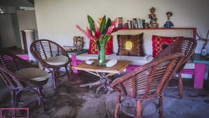 Un rincón acogedor con sillones de mimbre, una mesita y un jarrón decorativo.