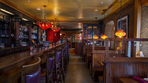 A bar with wooden furniture, a bar counter, and hanging pendant lights. - Washington House Hotel (Sellersville)