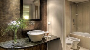 Een badkamer met een groot wastafel, een spiegel, een douche en een toilet.