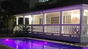 A nighttime view of a house with a swimming pool. - Hostal Marlyn Sai (San Andrés)