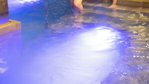 Dos personas en una piscina con un flotador en la pared.