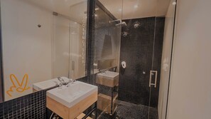 Slaapzaal | Badkamer | Een douche, designer toiletartikelen, een haardroger, handdoeken