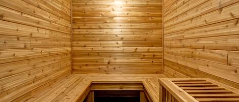 Una sauna de madera con bancos y piso de baldosas.