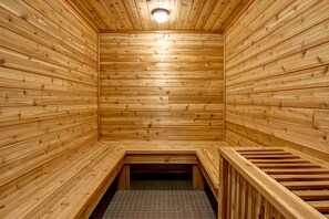 A wooden sauna with benches and a tiled floor. - Chateau Nova Yellowknife (Yellowknife)