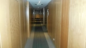A hallway with wooden walls and a patterned carpet. - Hotel Ritz Capital (Luanda)